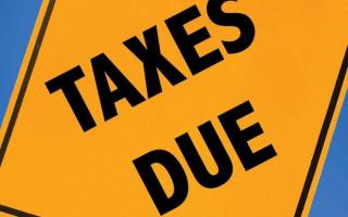Yellow warning sign that says taxes due