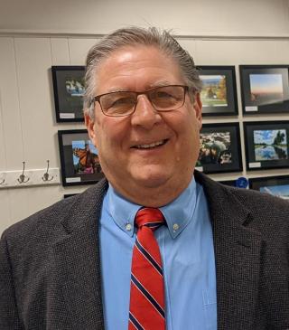 Photo of Mayor Flora Wearing a blue shirt and red tie